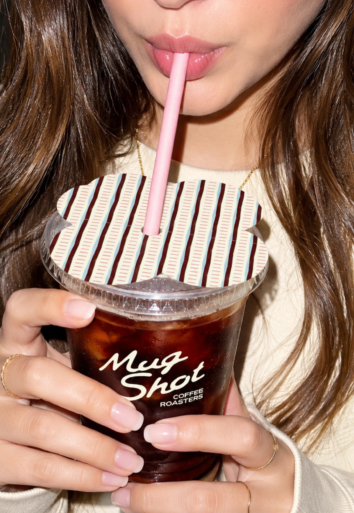 Mug Shot iced cup branding and striped lid topper design shown in a lifestyle shot