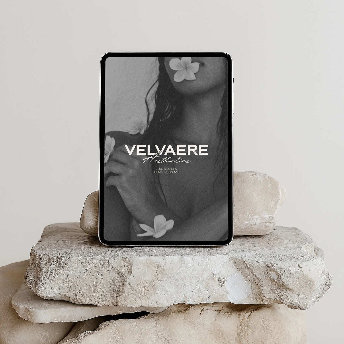 Velvaere Aesthetics brand identity on a tablet mockup: logo lockup over black-and-white floral editorial imagery