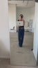 Madison Barnes, founder and designer of Madhouse Brands, taking a mirror selfie with her laptop in her design studio