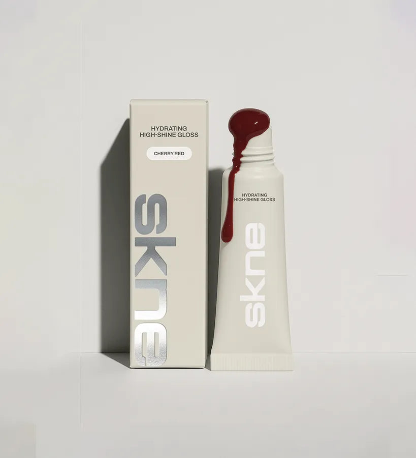 SKNE lip gloss packaging design in Deep Red: cream tube and box with vertical silver foil wordmark