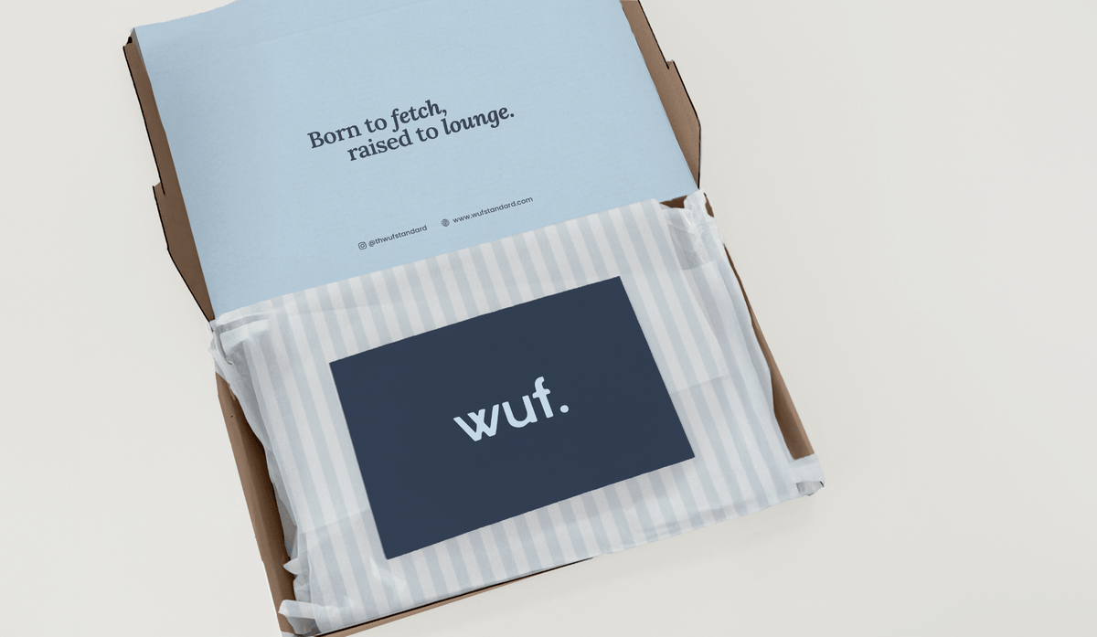 WUF packaging design: shipping box with a “Born to fetch, raised to lounge” insert, striped tissue and a navy logo card